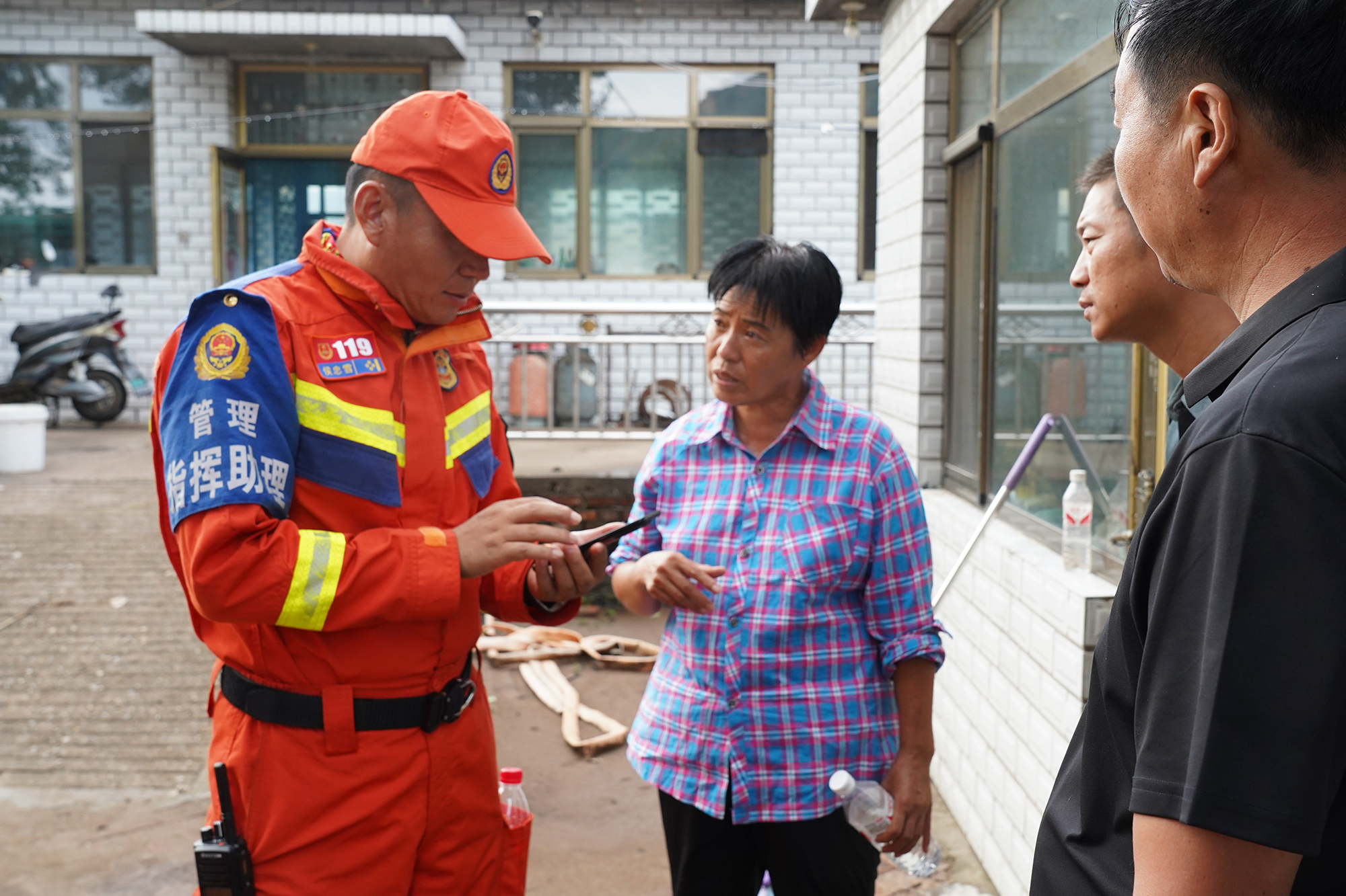 8月22日，遼寧省葫蘆島市建昌縣黑山科鄉(xiāng)楊樹底下村，消防員正在向村民詢問(wèn)村內(nèi)需要轉(zhuǎn)移的人員情況。遼寧省消防救援總隊(duì)供圖